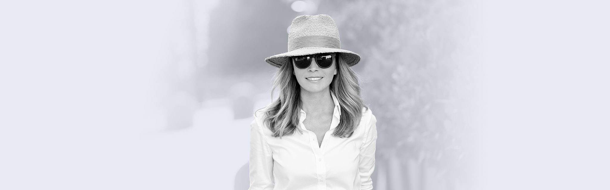 Une femme à chapeau et lunette de soleil