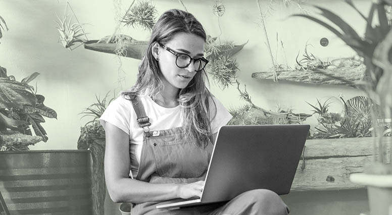 A girl with glasses consulting her laptop