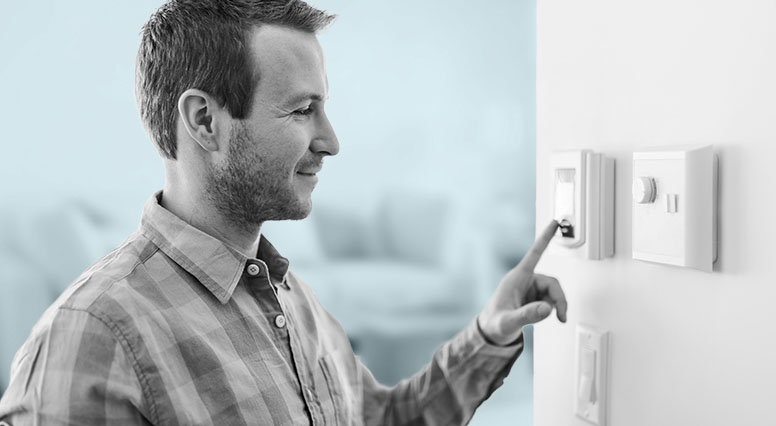 A man adjusts a thermostat